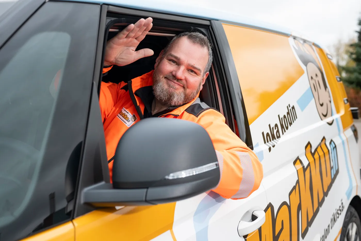 Markku kiinteistöhuollon ammattilaiskuljettaja tervehtii autosta