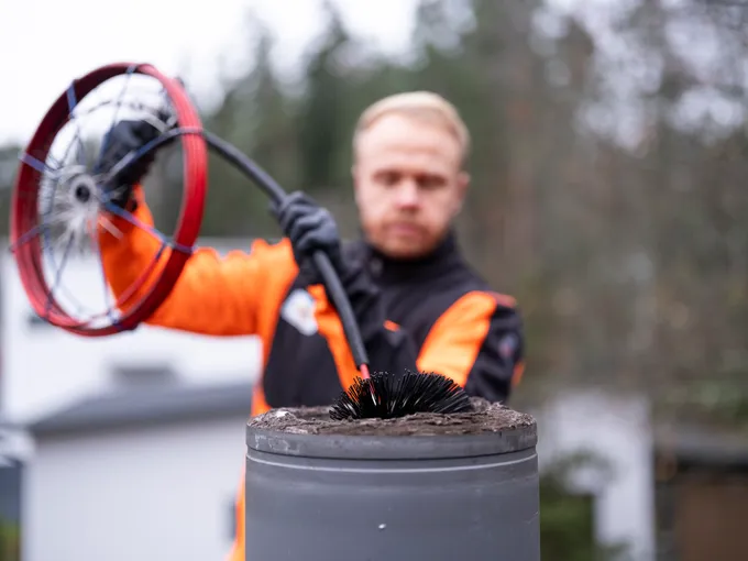 Markun nuohooja työssä taloyhtiön katolla