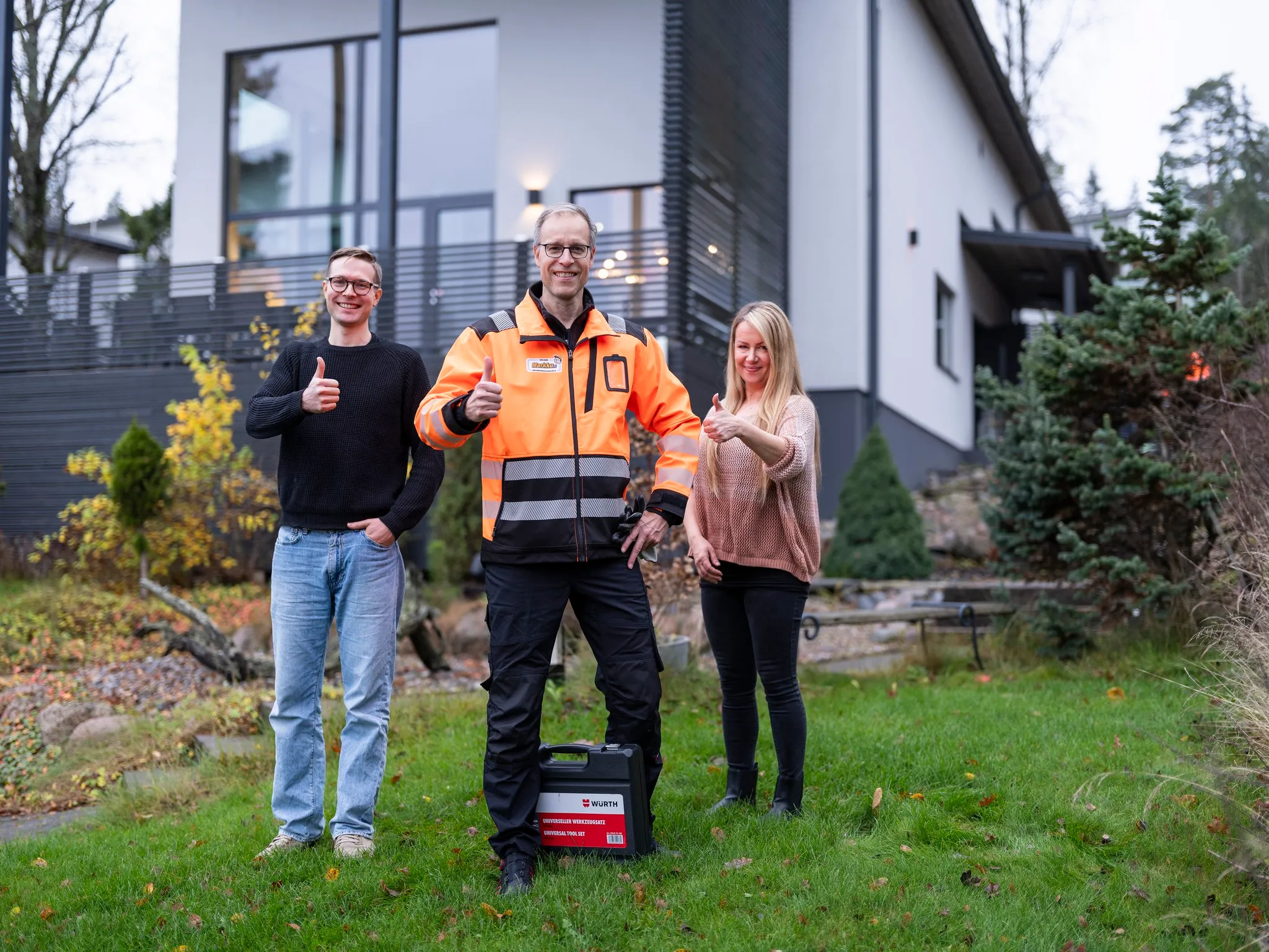 Tyytyväiset asiakkaat ja Markku-ammattilainen pientalon edessä